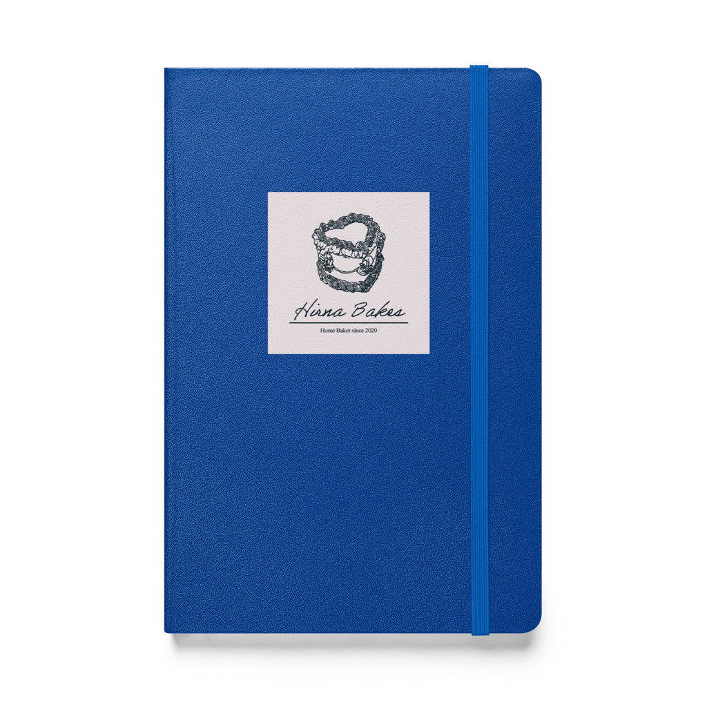 Blue hardcover notebook with Hirna Bakes logo sticker on the front